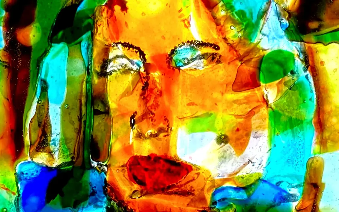 A fused glass panel by Mitch Bedke, lit from behind.